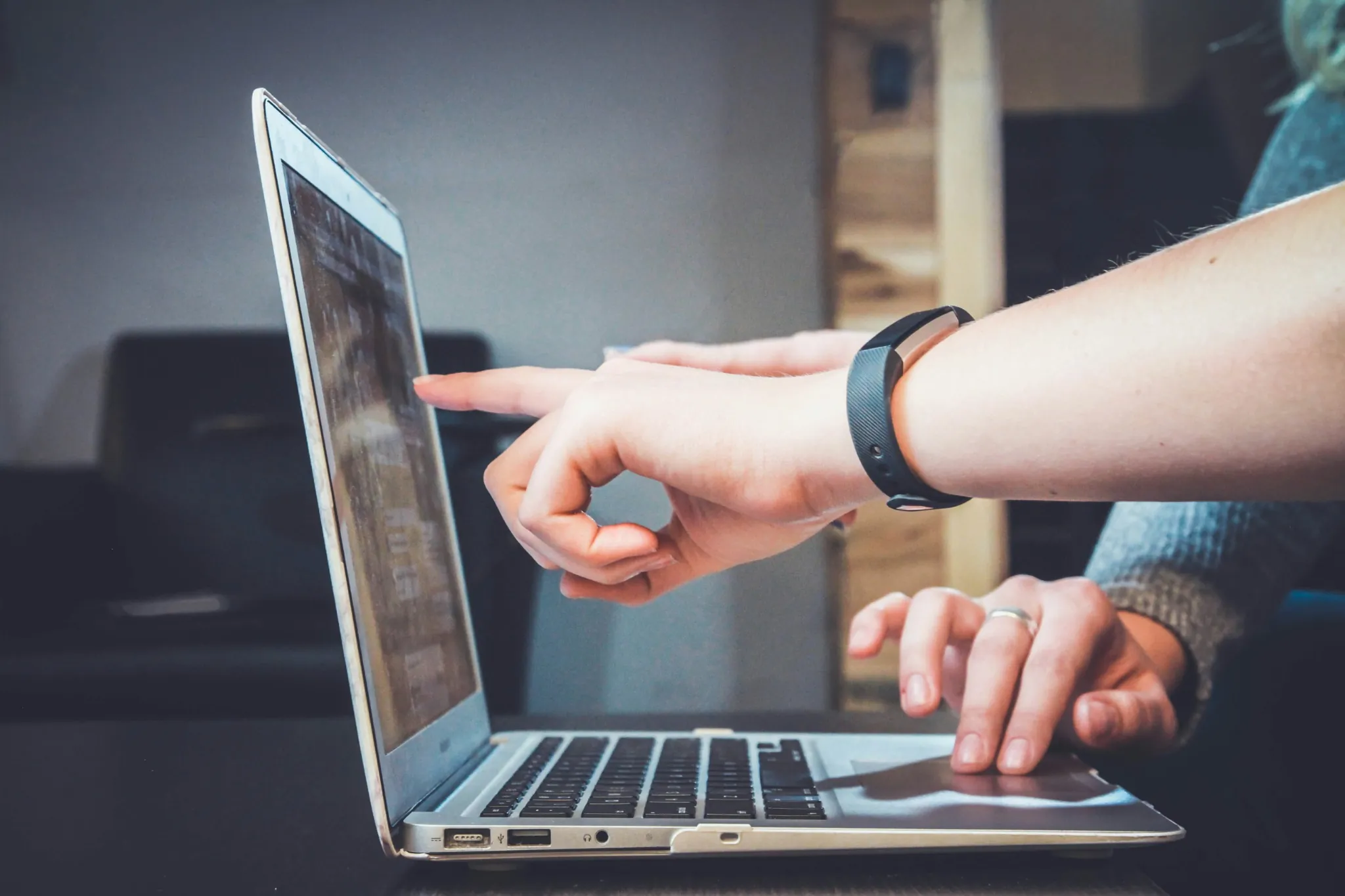 Hands pointing at laptop screen during testing