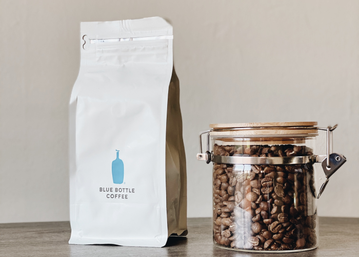 Coffee beans in a glass container and a pack of coffee 