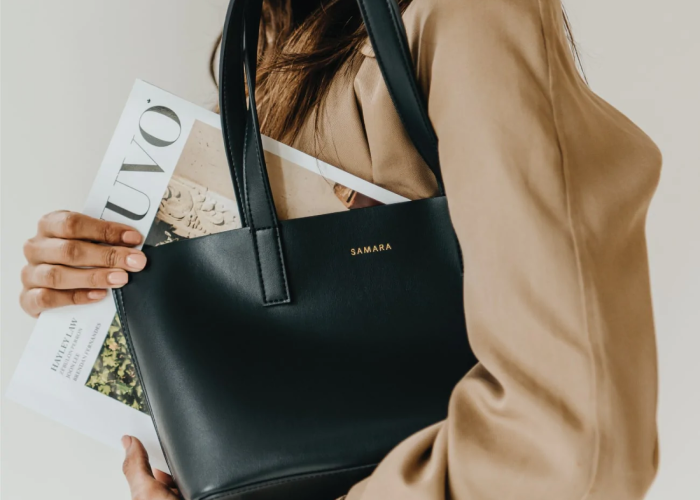 Girl in a beige coat with black mini tote by Samara