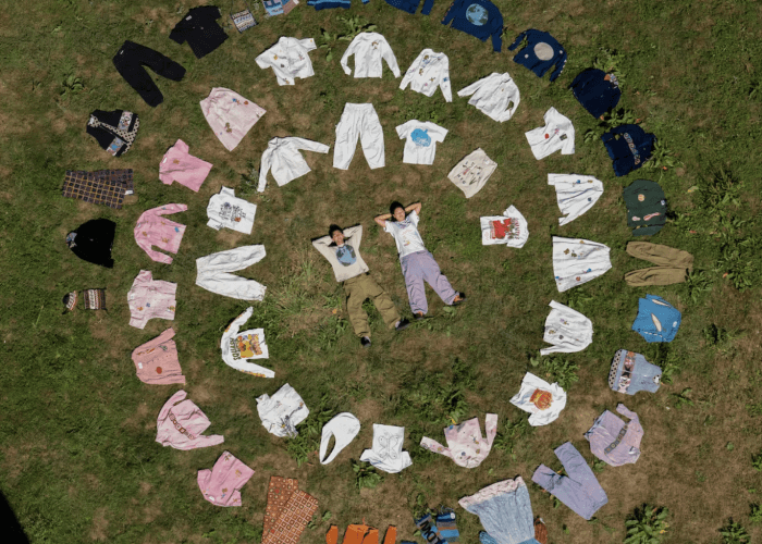 Two People Laying on the Grass in the circles of Story mfg clothes