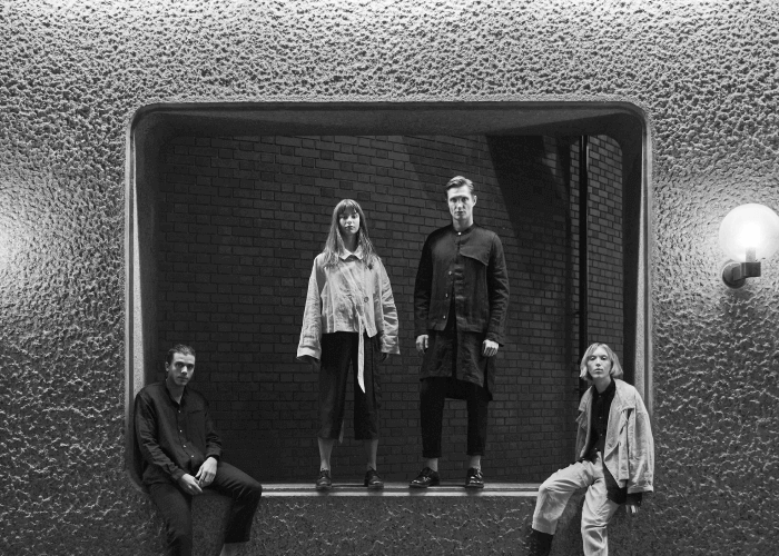 Black And White Photo with Two Men And Two Women Wearing Trace Collective Fashion