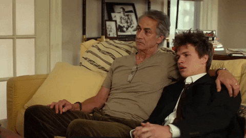 traditional dad type, a dad hugging his son on the couch GIF