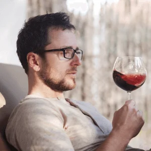 man drinking a glass of red wine from Wine Library