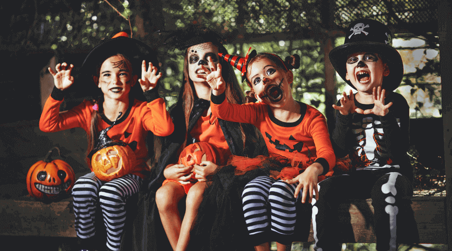 Vier Kinder, die gruselige Halloween Kostüme tragen